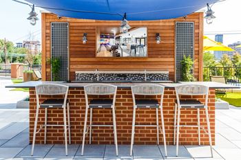 The outdoor bar area of a restaurant with a brick table and chairs